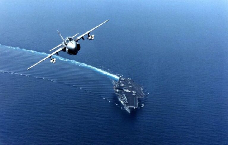 navy intruder plane flying over ship