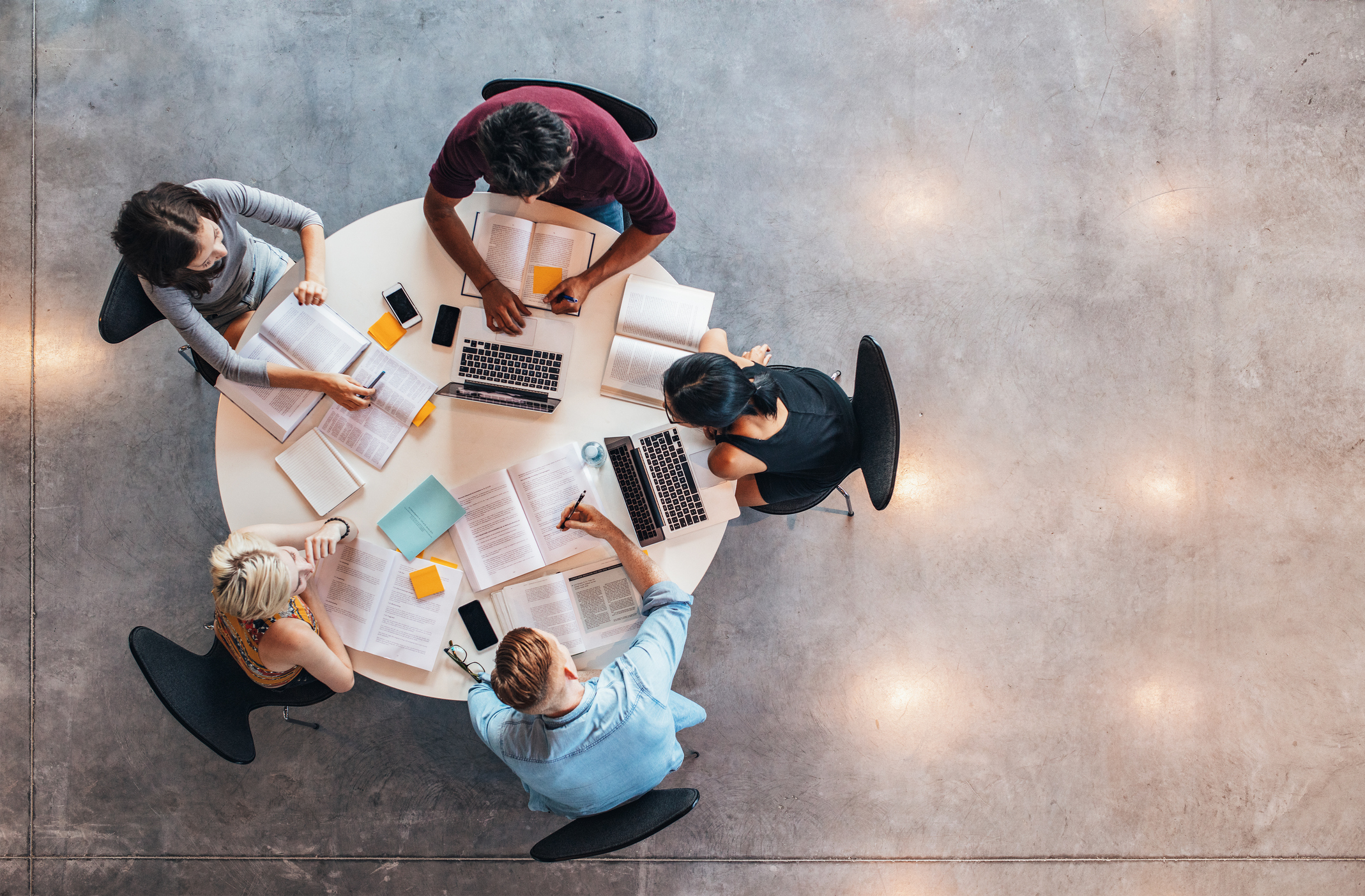 Top view of group of college students sitting together at table.